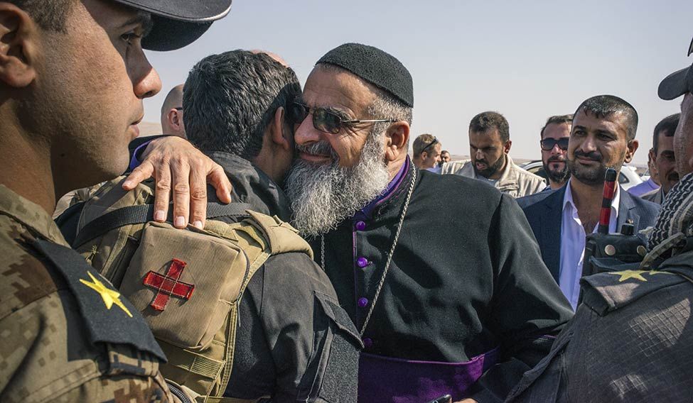 In good faith: A bishop greets an Iraqi soldier near the Bartella front line. In good faith: A bishop greets an Iraqi soldier near the Bartella front line.