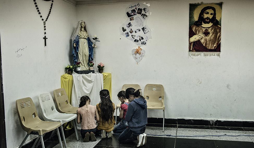 Hope springs eternal: Girls pray at a makeshift prayer room at a shopping mall in Erbil. Hope springs eternal: Girls pray at a makeshift prayer room at a shopping mall in Erbil.