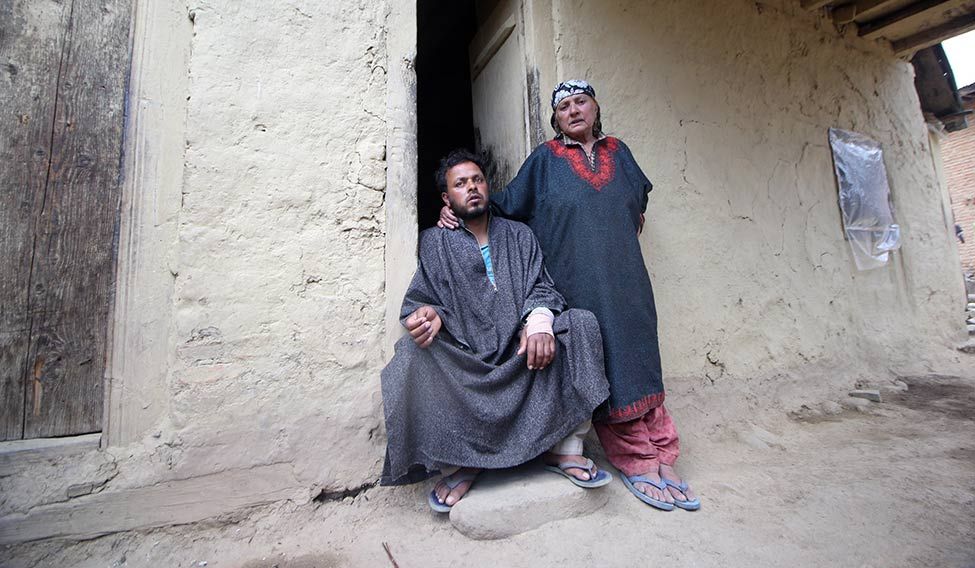 Rough ride: Farooq Ahmad Dar, who was tied to a jeep by the Army, at home with his mother | Umer Asif The young and the reckless