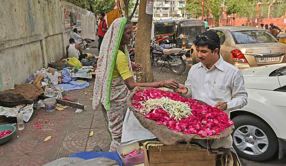 Buying flowers from Kalavati Dhembe. In his early teens, Manish would often sleep on the pavement in front of the Meetha Neem Dargah to escape his alcoholic father. Kalavati took care of him then | Amey Mansabdar In top gear