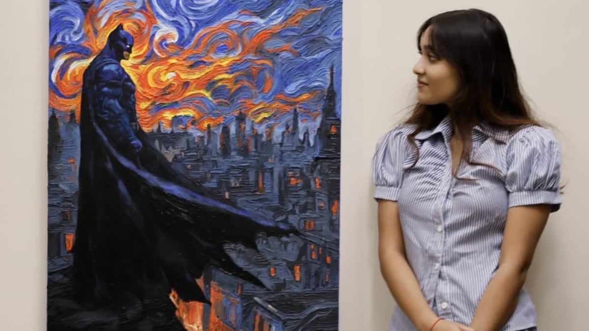 Emerging artist Vidhika Roy stands beside her painting of Batman