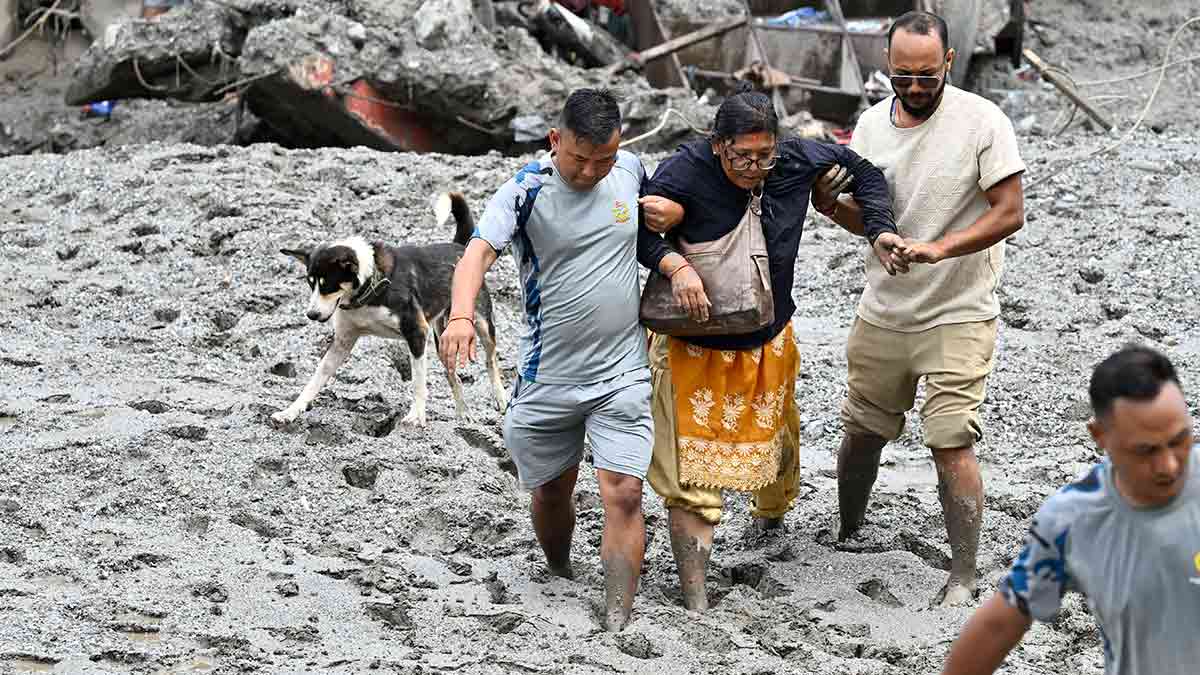 Close call: A woman is rescued after being trapped while trying to retrieve her belongings from her flood-damaged home in Dhunge, Nuwakot district.
