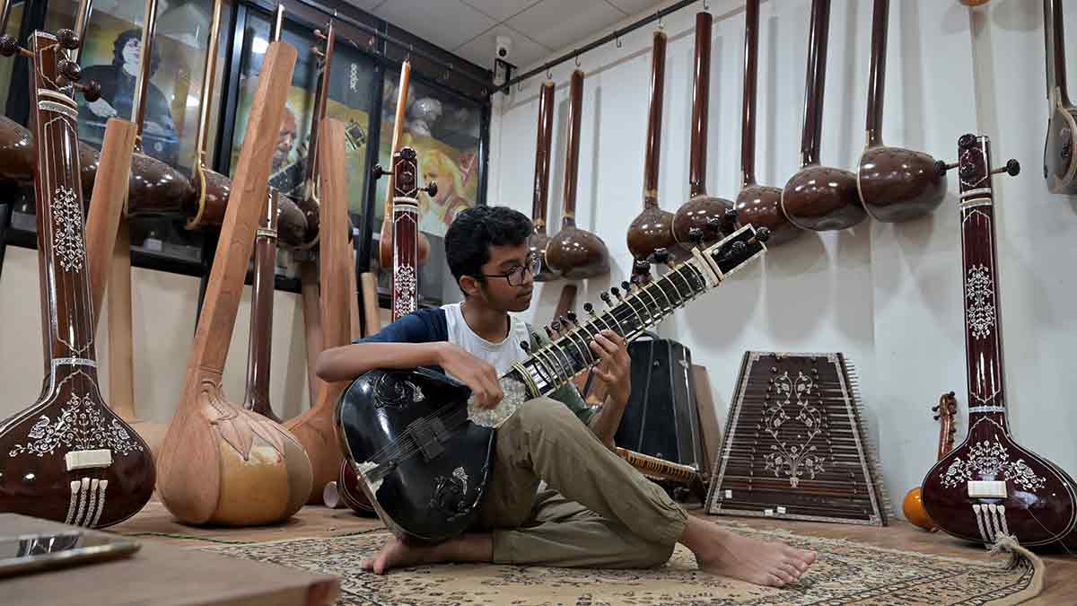 First notes: Taha Altaf Mulla, 15, plays the sitar at his family’s shop G.S. Musicals in Miraj.