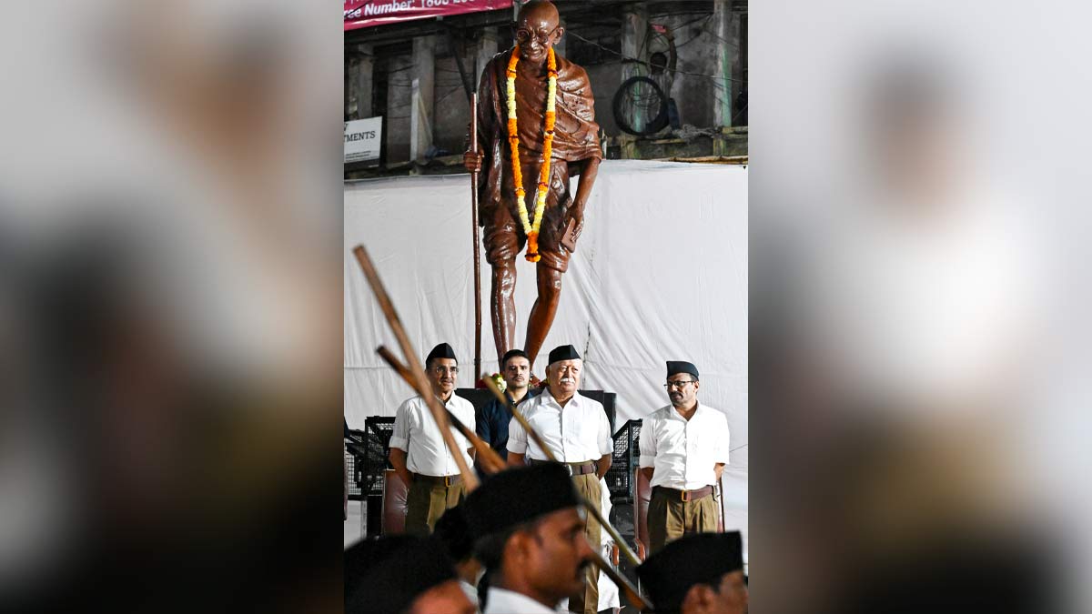 Bridging ideologies: Bhagwat (right) in front of a Gandhi statue during an RSS march | PTI