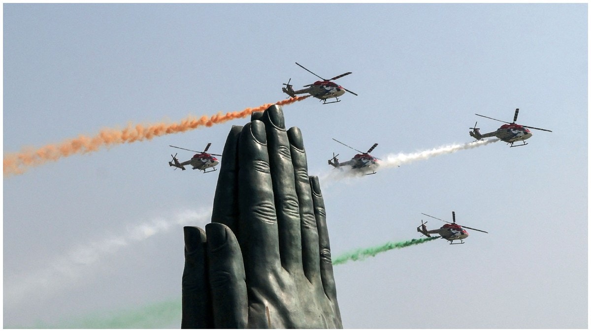 Indian Air Force (IAF) Sarang helicopters fly in a formation with tricolour trails during the 'Wings Over Ganges' air show 