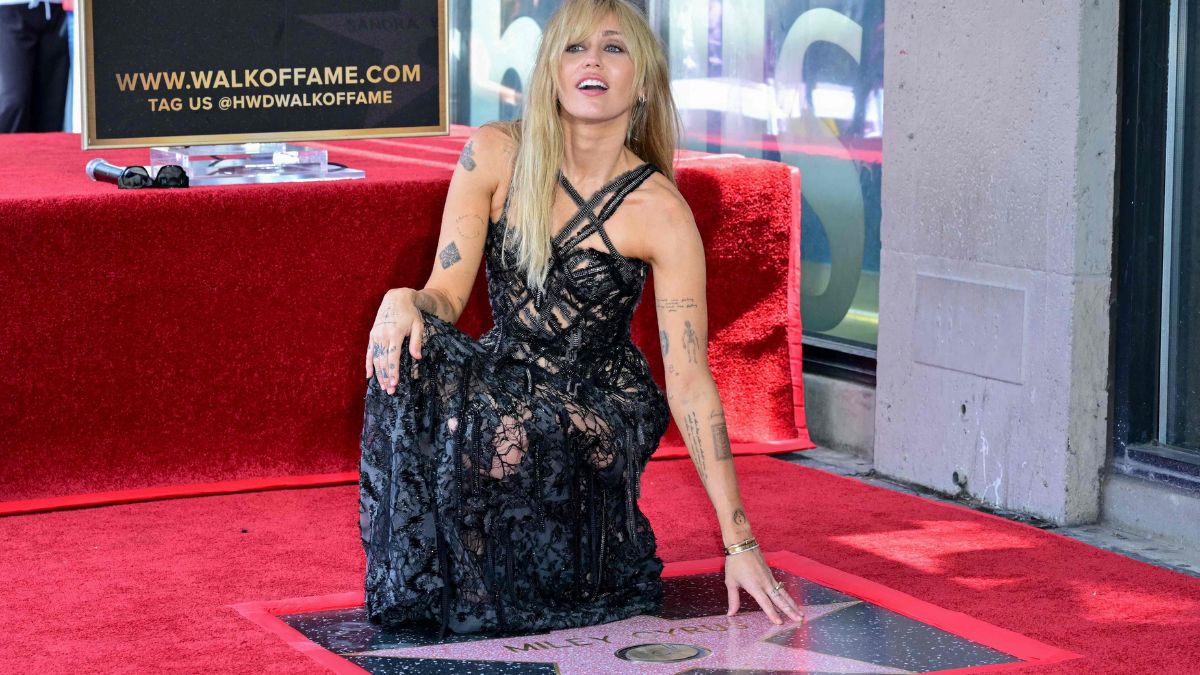 Miley Cyrus posing next to her star at the Hollywood Walk of Fame | AFP