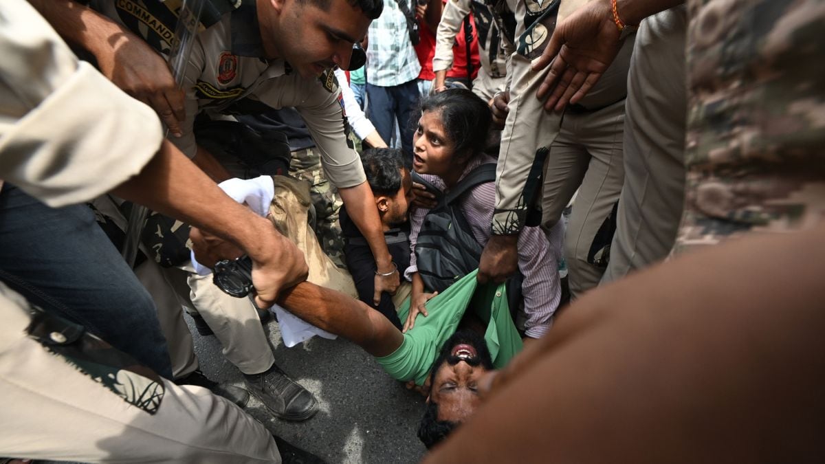 Security personnel detain a demonstrator during an Oct 11 protest demanding the resignation of India's CEC Gyanesh Kumar over alleged voter roll irregularities linked to the SIR | Kritajna Naik