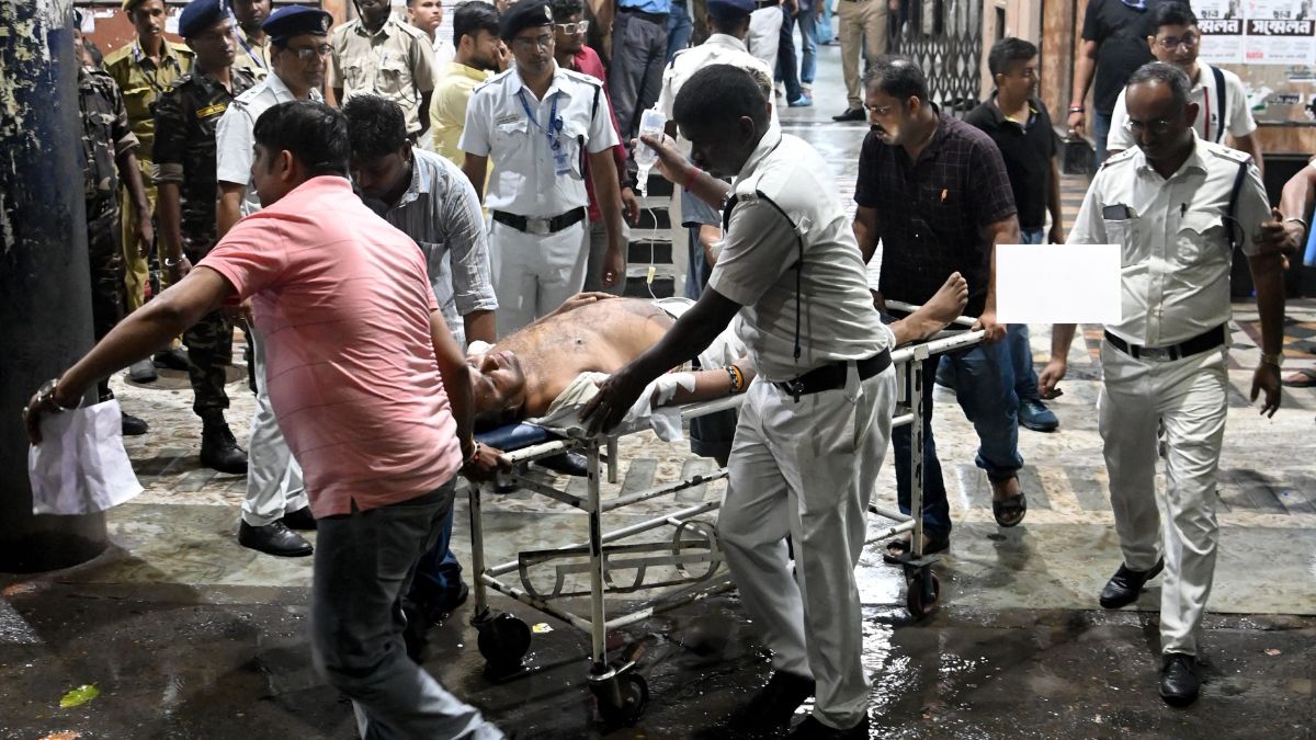 Medical workers move an injured police officer on a stretcher, following the Durga Puja Pandal stampede, in front of the emergency building of Calcutta Medical College and Hospital in Kolkata | AFP 