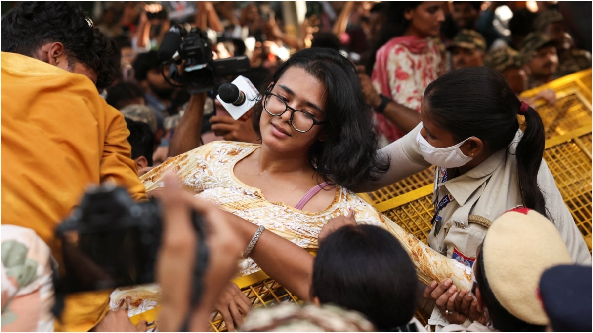 AISA national president Neha Bora climbs a police barricade near Ashoka Road as student activists attempt to march towards Jantar Mantar | PTI