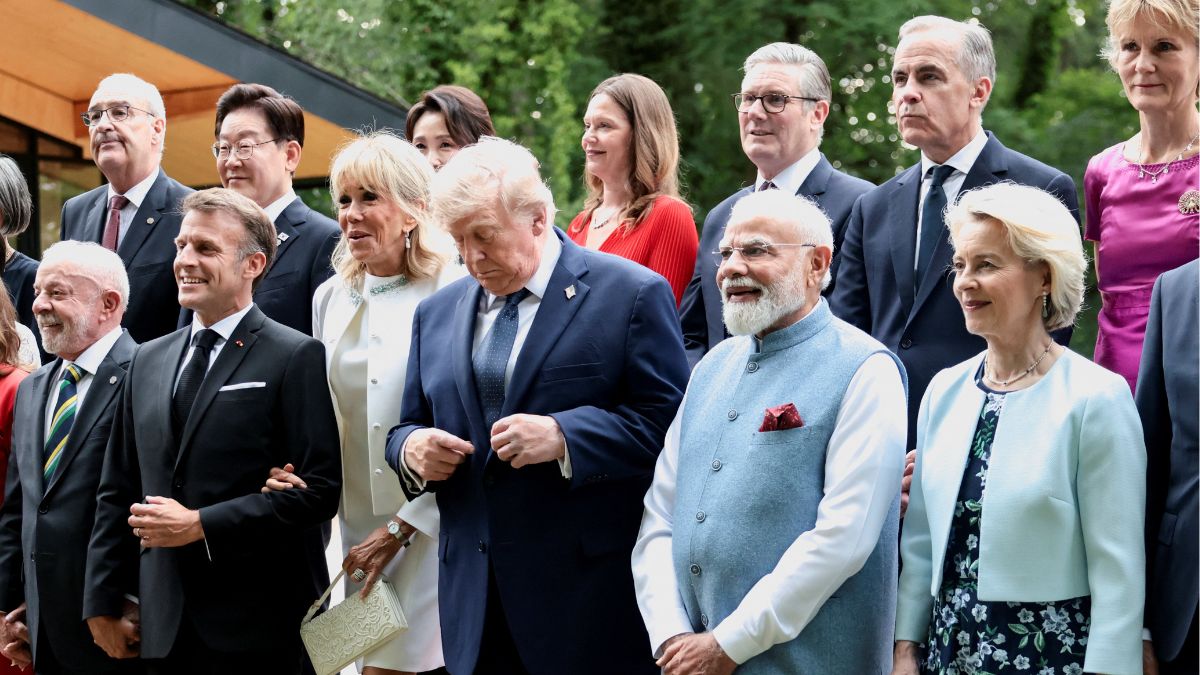 US President Donald Trump, next to Prime Minister Narendra Modi and France's Brigitte Macron, adjusts his suit for a family photo before a cultural performance and concert during the G7 summit, in Evian-les-Bains, France, June 16, 2026 | Reuters