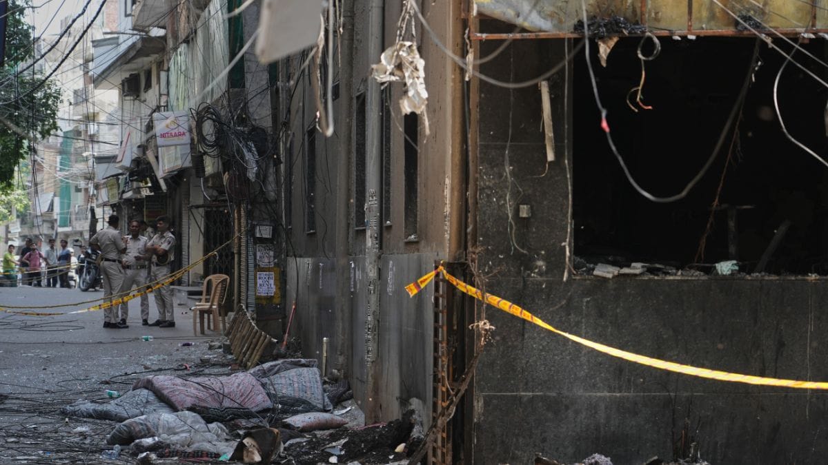 Policemen stand guard near a restaurant and hotel building that caught fire yesterday, in New Delhi | AP