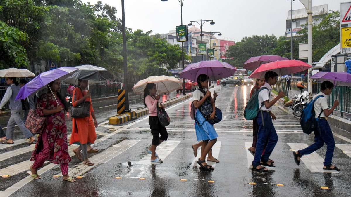  People cover themselves and cross a road during rainfall as monsoon arrives, in Kochi | AP 