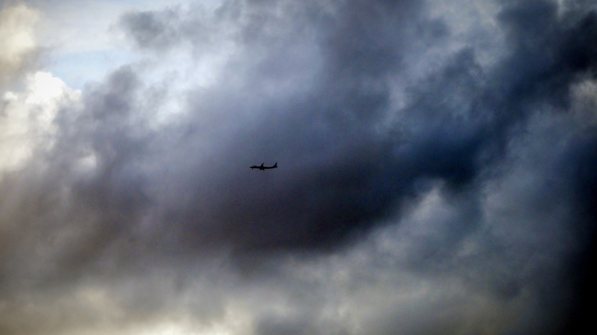 An aircraft flies over monsoon clouds above the city skyline on a rainy day in Thiruvananthapuram | PTI