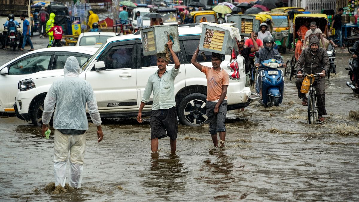 Commuters move on a waterlogged road amid rainfall, in Patna, Bihar | PTI