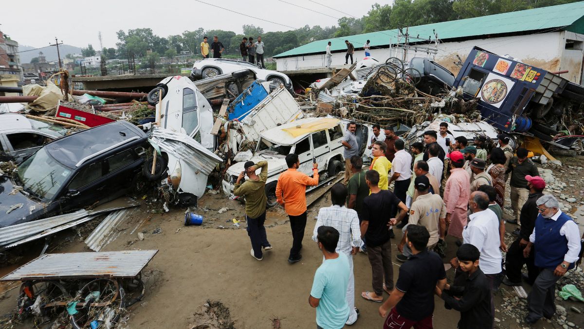 People gather next to vehicles piled up after a flash flood in Rajouri, Kashmir, on July 19, 2026 | Reuters