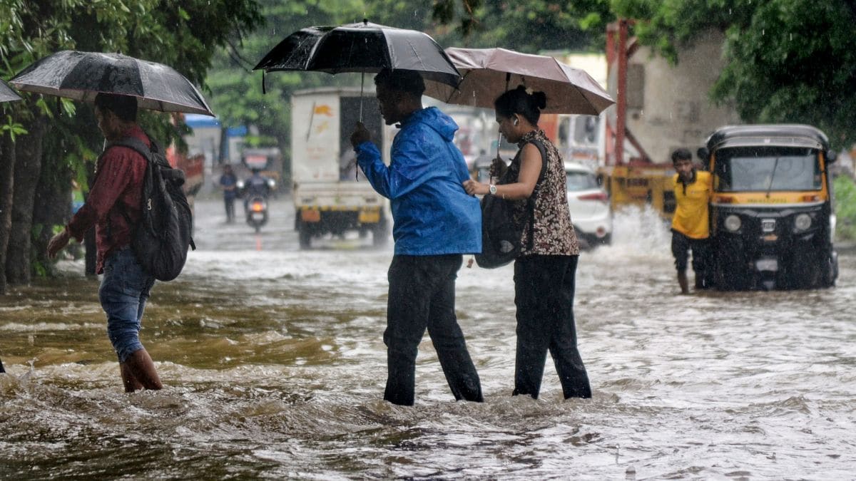People make their way through a severely waterlogged road amid rainfall in Navi Mumbai on July 2, 2026 | PTI