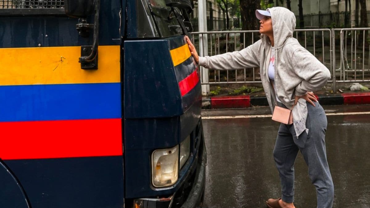 Riya Ahir standing in front of the police van carrying detained CJP protesters | X 