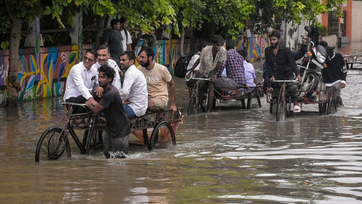 Commuters wade through a waterlogged Madhavbaug road following incessant heavy downpour, at Parvat Patiya area in Surat, Gujarat | PTI