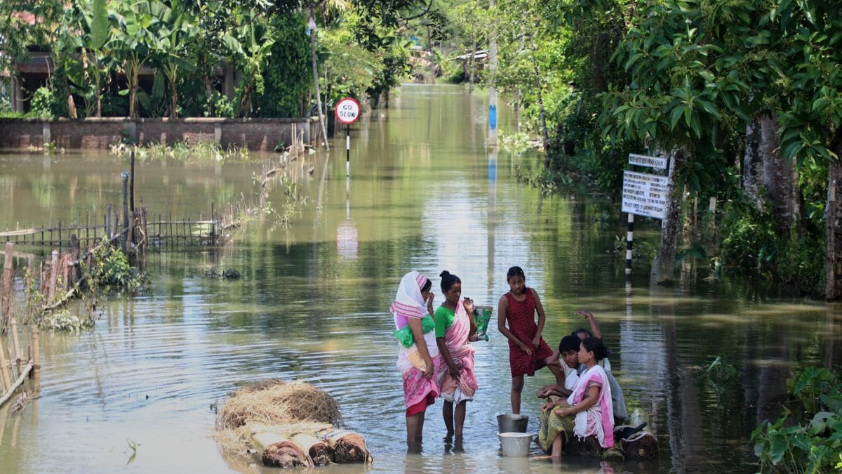 Flood affected villagers wait to cross the flood water in Sivsager, upper Assam | AP