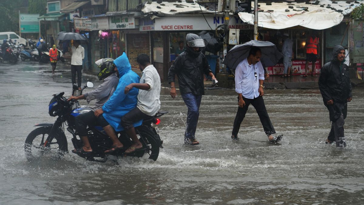 People walk through a water-logged street during monsoon rains in Mumbai | AP