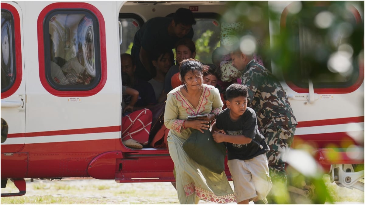 Army soldiers help a family disembark from a helicopter after they are rescued from an area affected by flash flooding in Nepal's Nuwakot district | PTI