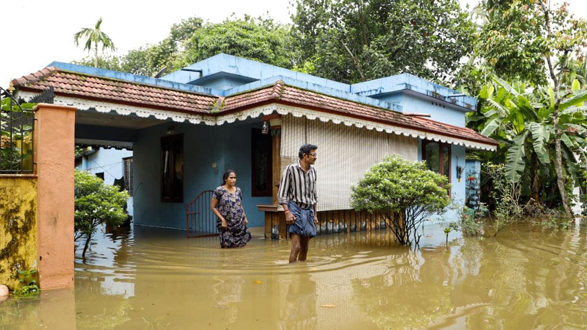 Residents wade through floodwaters outside their inundated homes after incessant monsoon rains caused widespread flooding, at Ranni, in Pathanamthitta district of Kerala | PTI 