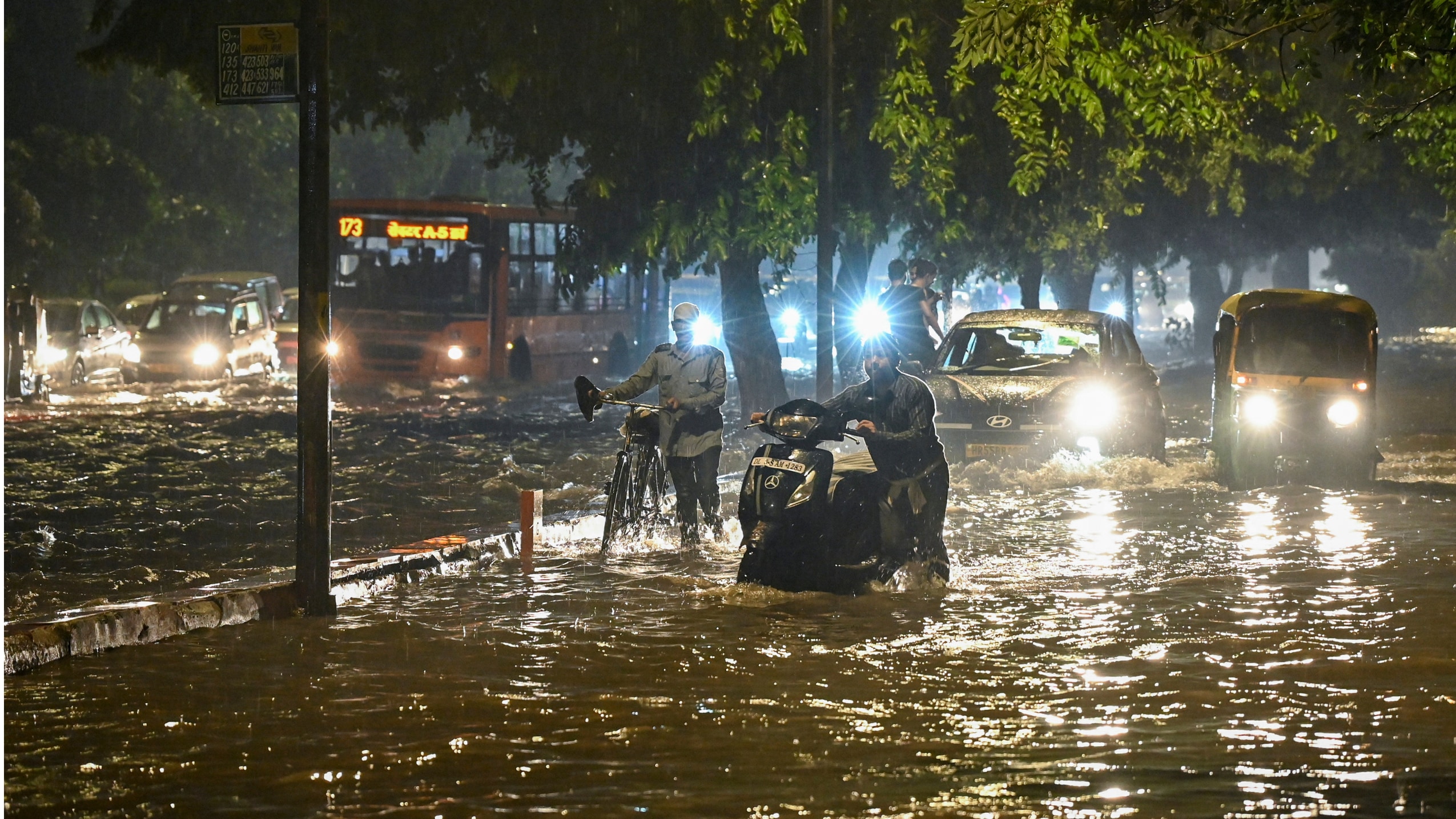 Commuters move on a waterlogged road, near Rajghat, in New Delhi | PTI