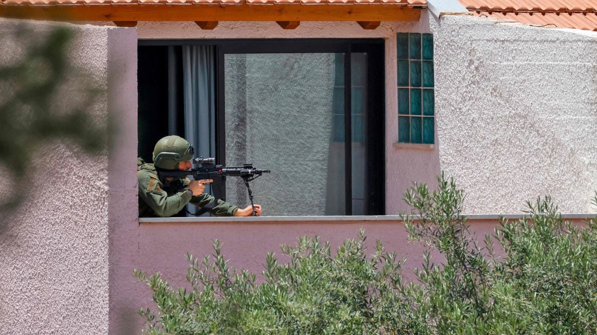 This picture taken from a position in northern Israel on the border with southern Leabanon shows an Israeli soldier taking position on the balcony of a building | AFP