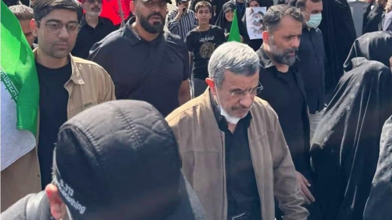 Ahmadinejad was recently spotted at the funeral of Ayatollah Ali Khamenei, donning a heavy coat and a mask and surrounded by IRGC guards | X/screenshot
