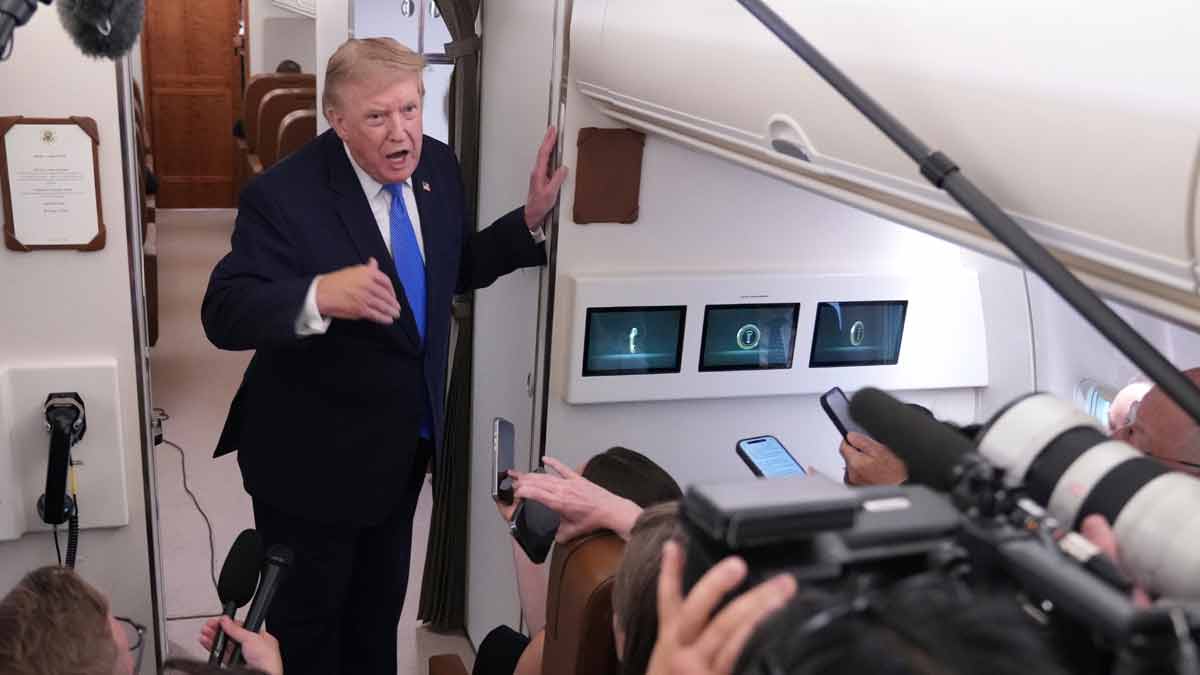 President Donald Trump speaks to reporters onboard Air Force One while returning to the White House | AP