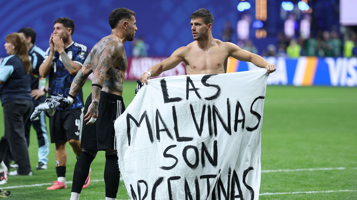 Argentina's players show a banner that reads in Spanish "The Malvinas (Falkland Islands) belong to Argentina" after winning the semi-final match against England | AFP