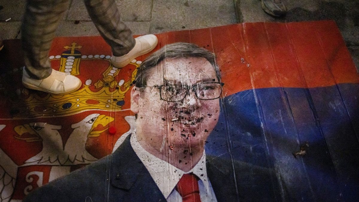 A person steps on an image of Aleksandar Vucic, Serbian Progressive Party (SNS) prime ministerial candidate, as supporters of the electoral list "Student List - Students Win" celebrate at the Parliament building after Vucic conceded defeat in the parliamentary election, in Belgrade, Serbia | Reuters 