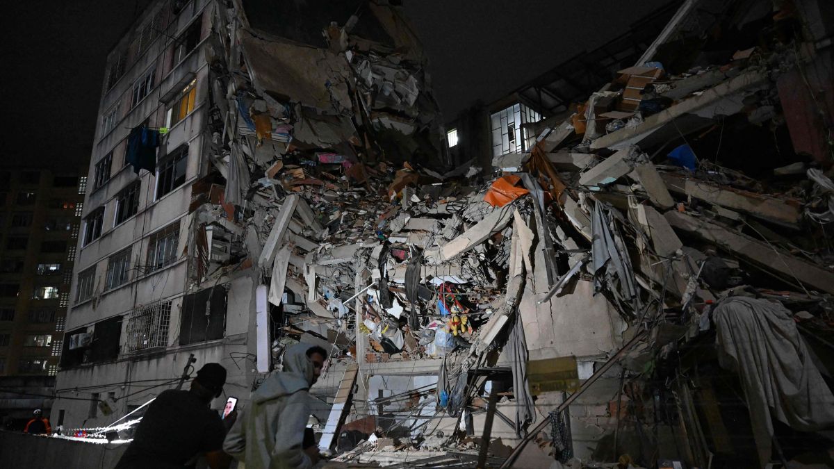 People look at a collapsed building in the Altamira neighbourhood following an earthquake in Caracas | AFP 