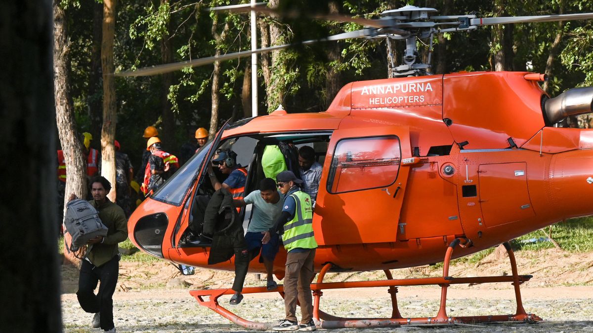 Rescued residents disembark a helicopter at an army camp following flash floods, in Battar Bazar town of Nepal's Nuwakot district on August 27, 2026 | AFP