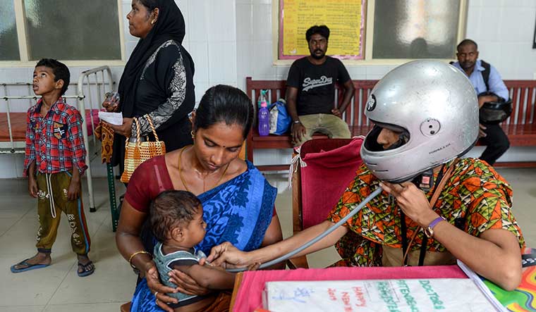 Head-on protest: A doctor at Egmore Government Children's Hospital in Chennai wears a helmet while checking a patient | AFP
