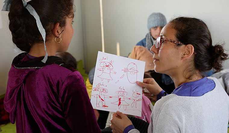 Lending an ear: Saad with an Iraqi girl whose parents were killed by Islamic State.