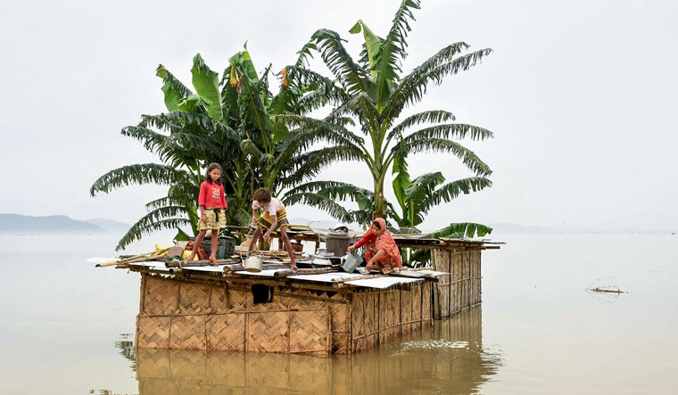 File- A family marooned on the top of a hut in the flood-hit locality of Panikhaiti in Kamrup district of Assam | PTI