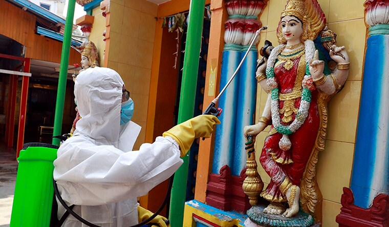 Pray and spray: A soldier wearing protective gear disinfects a temple to curb the spread of Covid-19 in Naypyitaw, Myanmar, on April 1. Myanmar, which has been criticised for its slow response to the pandemic, recorded its first Covid-19 death on March 31 | AP
