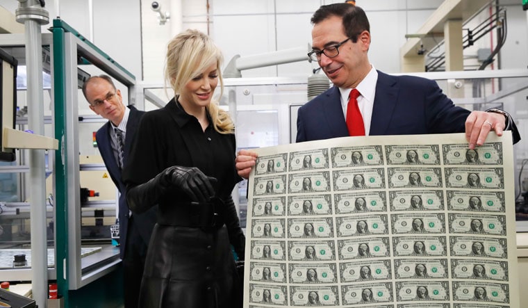 From the money mill: US Treasury Secretary Steven Mnuchin showing his wife, Louise Linton, the first dollar notes bearing his signature in 2017 | AP