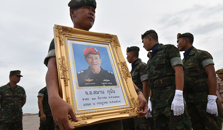 A hero, lost: A Royal Thai Navy soldier carries a portrait of Saman Kunan, who died during the rescue operation | AFP