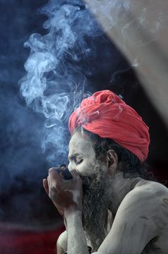 Holy, high: a naga sadhu smoking chillum at the sadhus’ tent area.