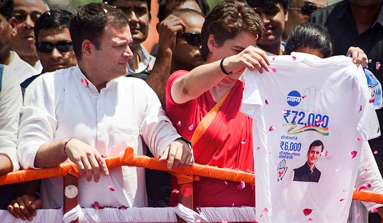 File picture- Rahul Gandhi looks on as his sister and party General Secretary Priyanka Gandhi Vadra displays a jersey highlighting the party's 'NYAY' scheme | PTI