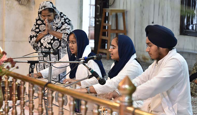 Hymns for the divine: Amandeep Kaur and Anmol Kaur with their brother, Jaivin Singh, perform kirtan at Gurdwara Bala Sahib in Delhi | Aayush Goel