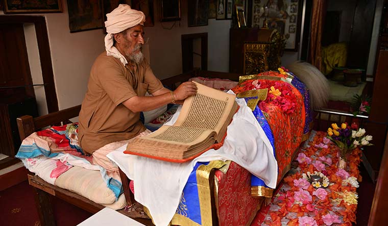 Neem Muni, caretaker of Gurunanak Muth in Kathmandu, showing a handwritten copy of Guru Granth Sahib | Arvind Jain