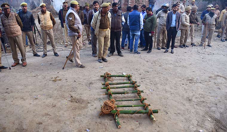 Pall of gloom: Police and others wait outside the victim’s home for the body to be taken for the last rites | J. Suresh
