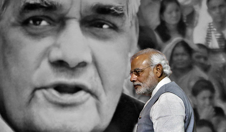 Saffron icons: Modi at an event in July 2014. In the background is a picture of Vajpayee | Reuters