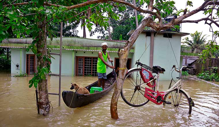 Nature’s fury: A man tries to save his cycle during the floods in Kerala in 2018 | AP