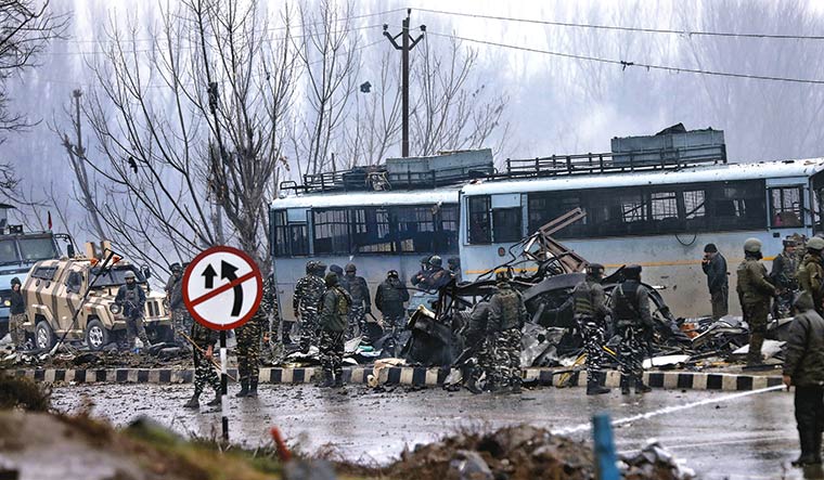 After shock: Security personnel inspecting the wreckage at Lethpora | AP