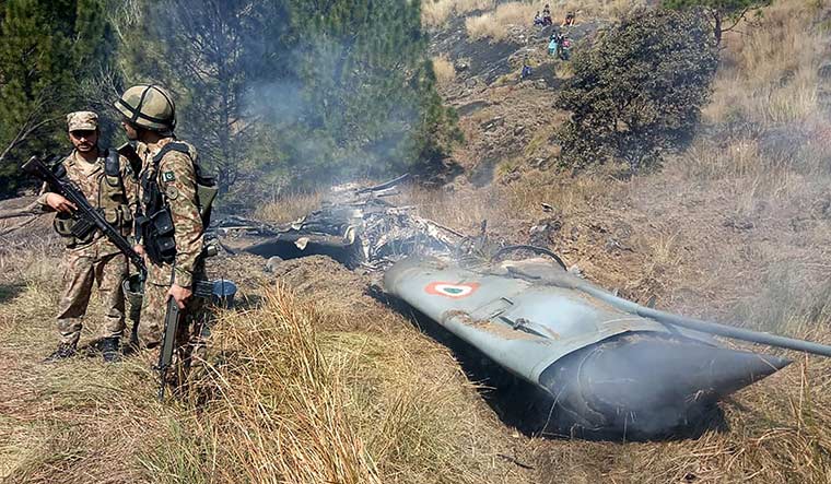 Tit-for-tat: Pakistani soldiers stand next to what Pakistan says is the wreckage of an Indian fighter jet that was shot down in PoK on February 27 | AFP