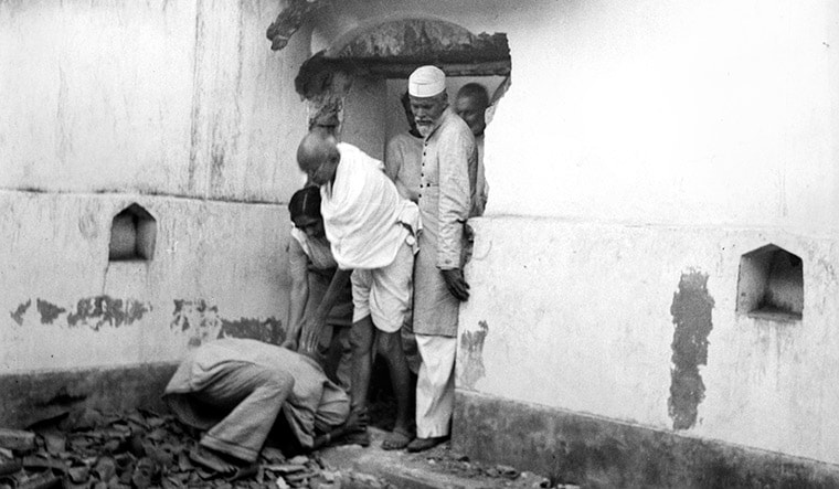 Peace mission: Gandhi at a ruined house in Bihar in 1947 | Photo Courtesy: Navajivan Trust